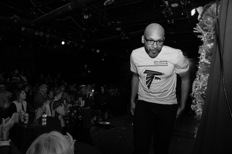 Plug Chapman taking the stage at a packed comedy club